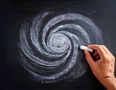 Hand drawing a spiral with chalk on a blackboard, education conceptの素材
