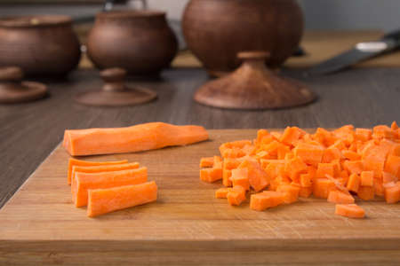 Diced raw carrots on a chopping boardの写真素材