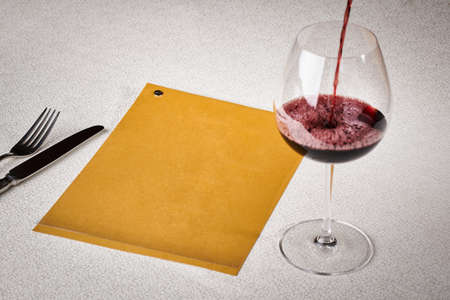 ood concept, top view, copy space. Glass of wine on a serving table with fork and knife