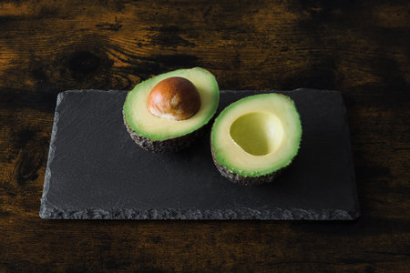 Avocado on a black background cut open.