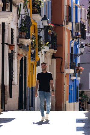 young man visiting the santa cruz neighborhood and walking the streets of alicanteの写真素材