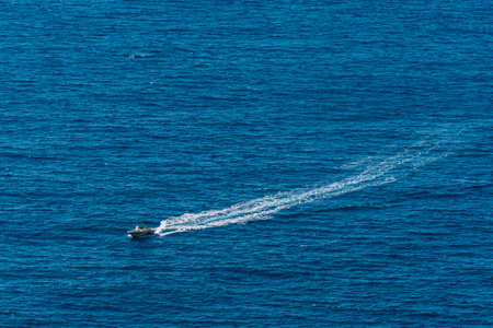 small boat sailing near the cliffsの写真素材