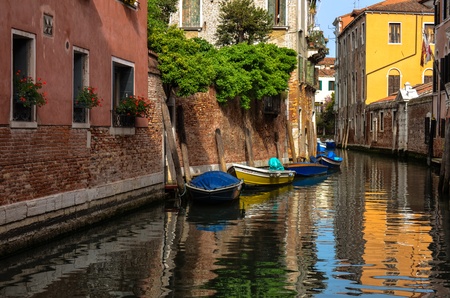 Peaceful reflections on a Venice Canal with boats waiting のeditorial素材