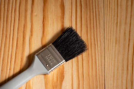 Paintbrush placed on a wooden surface and space for text to the sideの写真素材