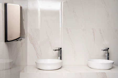 Sink with two dispensers, one for soap and the other for sanitary napkinsの写真素材