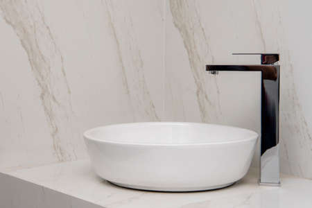 Sink with mixer on a marble base and wallsの写真素材