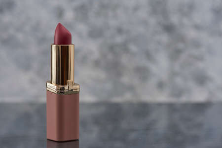 Pink lipstick on a marble surface with a white background with gray and space for text on the right sideの写真素材