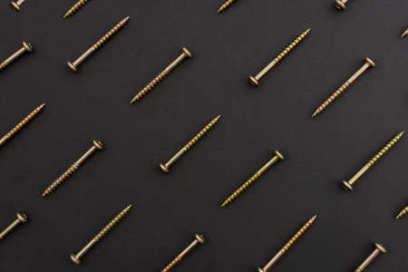 Screws arranged on a black surface