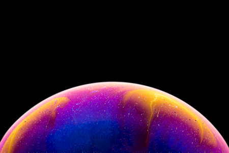 Soap bubble simulating the atmosphere of a planet with different shapes, colors and a black backgroundの写真素材