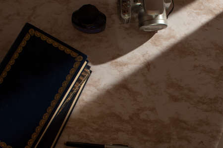 Ink books and camera on a table with light coming through the windowの写真素材