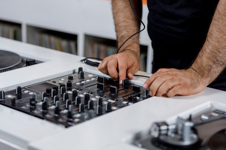 Dj hands manipulating the audio mixer.の写真素材