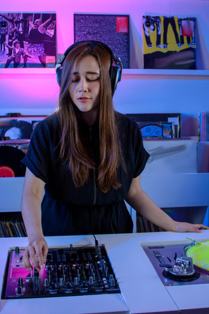 Latin Dj girl mixing music in a record store, with a turntable and vinyl records.