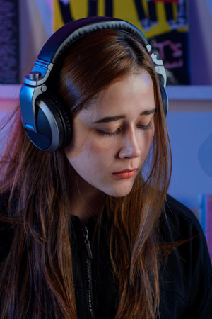 Beautiful latin dj woman with headphones mixing music in a vinyl record store. Retro DJ girl conceptの写真素材