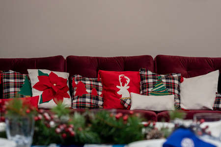 Christmas design cushions on an armchair in a house with a white wall in the backgroundの写真素材