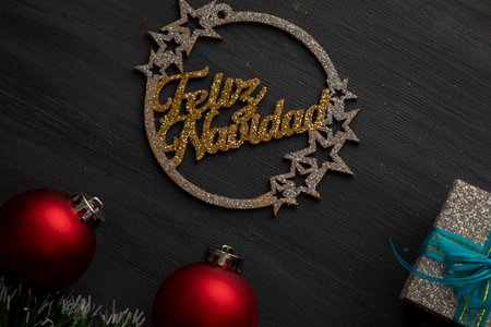 Christmas background- with gold sign, red spheres and silver gifts with blue bow on black backgroundの写真素材