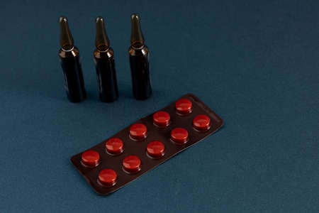 Group of drugs with pills and ampoules with a blue background and space for text