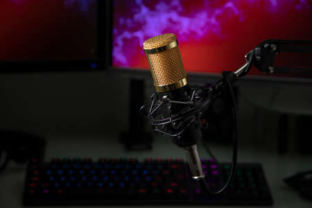 Professional microphone with gamer workstation in the background and headphonesの写真素材
