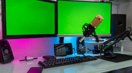 workstation with microphone and monitors with green screen for montageの写真素材