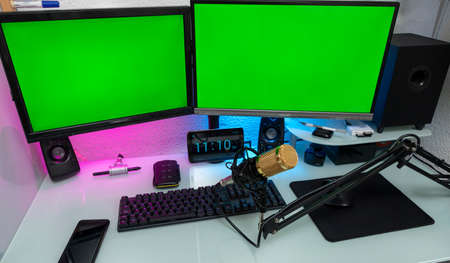 workstation with microphone and monitors with green screen for montageの写真素材