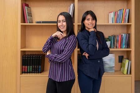 Portrait of two Mexican women in office clothes. Portrait of two female entrepreneurs in formal wear in the lobby looking at the camera.の写真素材