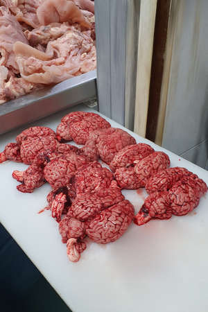 butcher board with beef brains on it. Beef brains on a butchers table