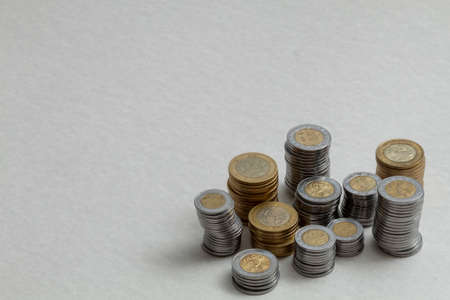 Group of coins stacked on the corner of a table, with copy space. Mexican pesos.の写真素材