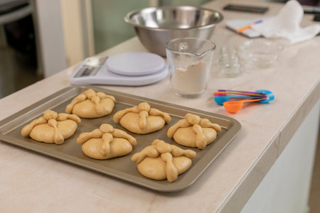 Tray with bread of the dead ready to bake, on the counter of a Mexican kitchenの写真素材