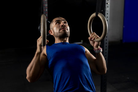 close up of a latin gymnast doing ring rows on gymnastic hoopsの写真素材