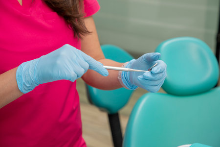 Close up on the hands of a female dentist holding a dental mirrorの写真素材