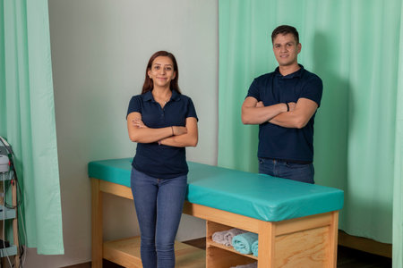 a couple of physiotherapists standing in their office looking at cameraの写真素材