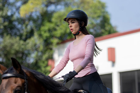 Close up on a young woman riding a horse in an equestrian centerの写真素材