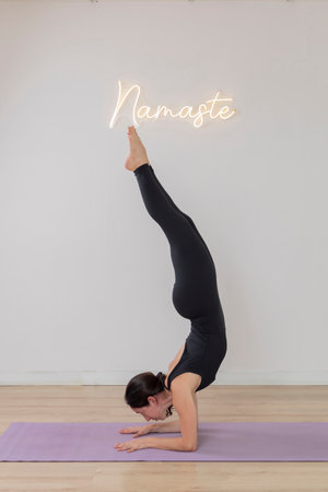 Young latin woman does a handstand yoga pose