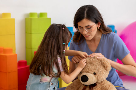 Pediatrician interacting with her patient using a teddy bear during therapy sessionの写真素材