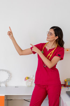 Pediatrician pointing to wall in pediatric officeの写真素材