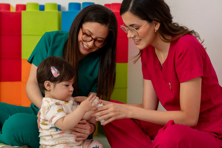 Pediatricians assisting baby girl in play therapy sessionの写真素材