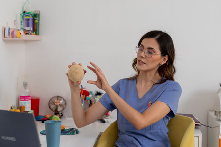 Pediatrician using knitted ball for explanation during online consultationの写真素材