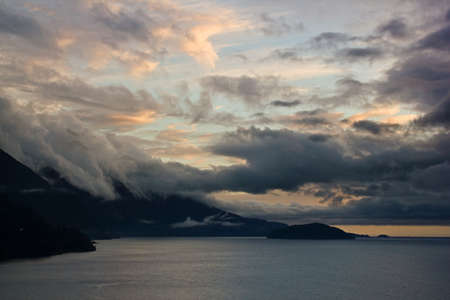 Beautiful sky conditions surrounding mountains and oceanの写真素材