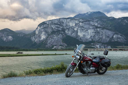 Cruser motorcycle on a dirt road with a moutainous background (Chief Mountain). Taken in Squamish, BC, Canadaの写真素材
