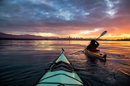 Kayakers enjoying the beautiful sunrise. Picture taken near Kitsilano Beach, Vancouver, BC, Canada.の写真素材