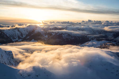 Beautiful Aerial Landscape View of the Mountain Range covered in Clouds during Sunset. Picture taken North of Vancouver, British Columbia, Canada.の写真素材