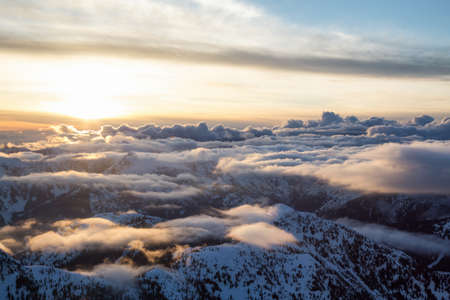 Beautiful Aerial Landscape View of the Mountain Range covered in Clouds during Sunset. Picture taken North of Vancouver, British Columbia, Canada.の写真素材