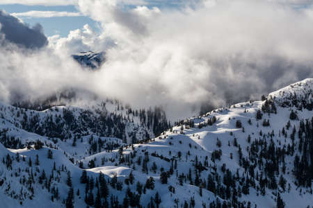 Aerial landscape view of the snow and cloud covered mountain range North of Vancouver, British Columbia, Canada.の写真素材