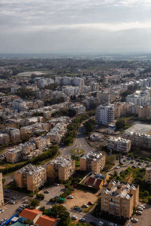 Aerial view of a residential neighborhood in a city during a cloudy and sunny sunrise. Taken in Netanya, Center District, Israel.の写真素材