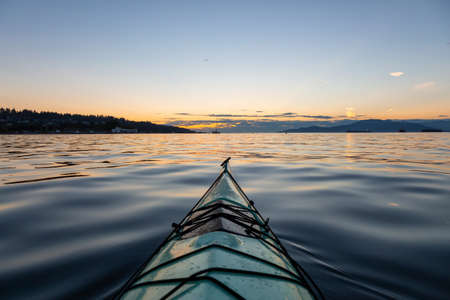 Sea Kayaking during a vibrant sunny summer sunset. Taken in Vancouver, BC, Canada.の写真素材