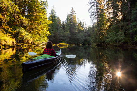 Girl kayaking in the beautiful river during a sunny summer morning. Taken in San Josef Bay, Cape Scott, Northern Vancouver Island, BC, Canada.の写真素材