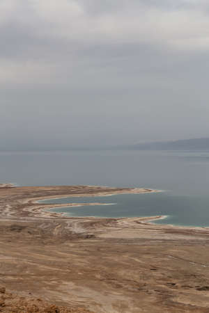 Beautiful aerial view of a mountain desert landscape and dead sea during a cloudy and sunny day. Taken near Masada National Park, Israel.の写真素材