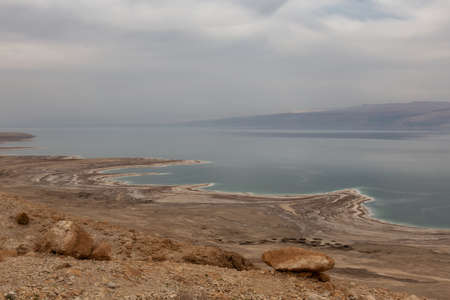 Beautiful view of a mountain desert landscape and dead sea during a cloudy and sunny day. Taken near Masada National Park, Israel.の写真素材