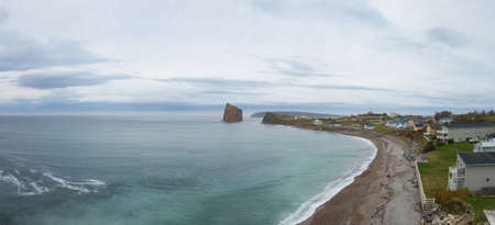 Aerial panoramic view of a beautiful modern town on the Atlantic Ocean Coast during a cloudy sunset. Taken in PercÃ©, Quebec, Canada.の写真素材