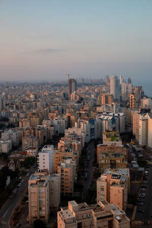 Aerial view of a residential neighborhood in a city during a vibrant and colorful sunrise. Taken in Netanya, Center District, Israel.の写真素材