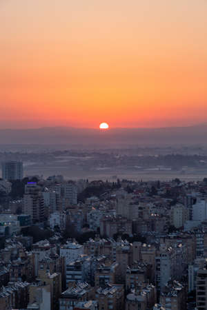 Aerial view of a residential neighborhood in a city during a vibrant and colorful sunrise. Taken in Netanya, Center District, Israel.の写真素材